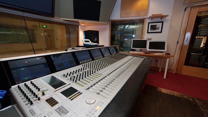 A large recording studio with many monitors and speakers.